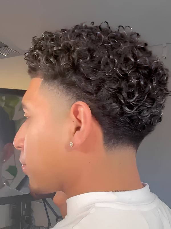 Short curls, coils, or waves with mid taper fade